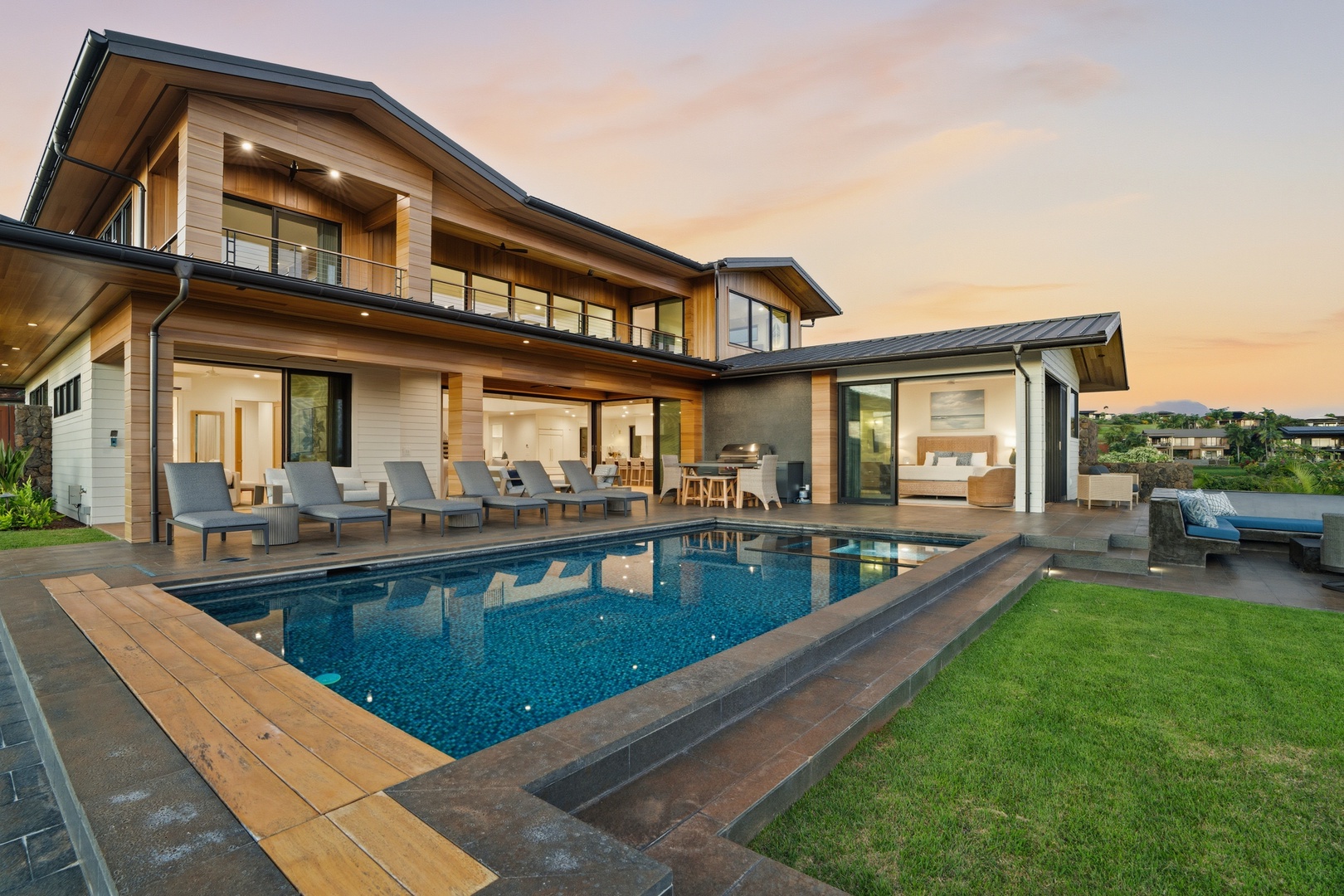 Koloa Vacation Rentals, Hale Laule'a at Kukui'ula - Modern luxury home featuring swimming pool, hot tub and outdoor entertaining spaces at sunset.