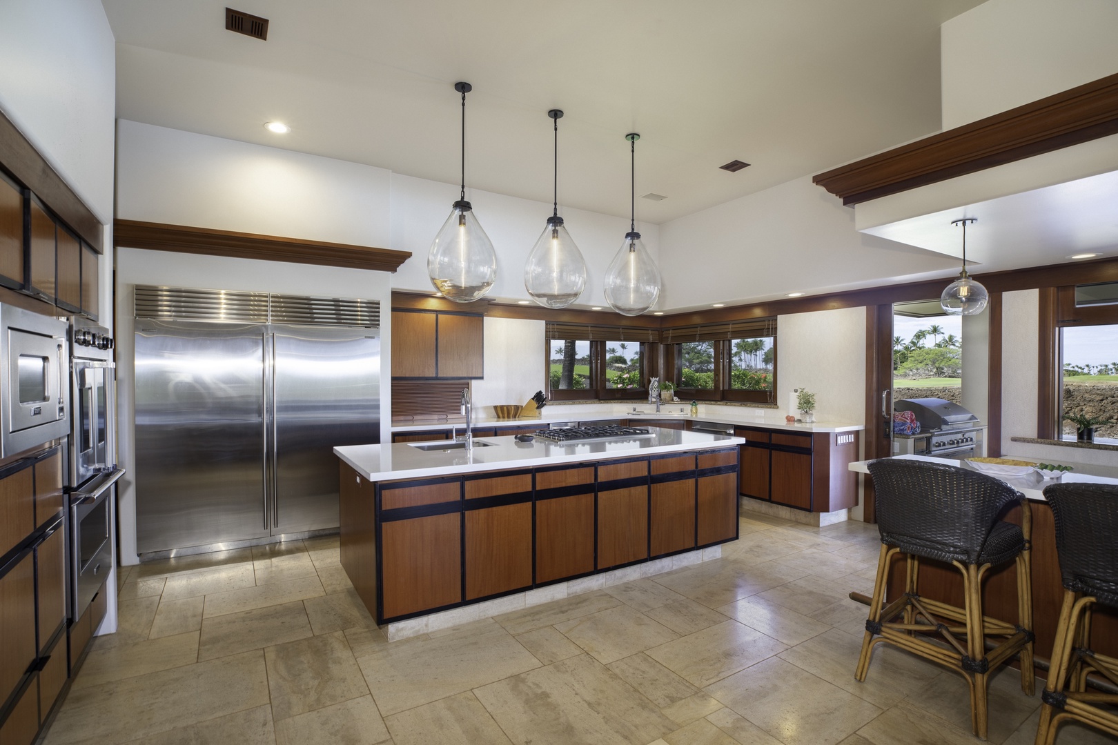 Kamuela Vacation Rentals, Champion Ridge 7 - Your gourmet kitchen invites culinary adventures with gleaming stainless appliances, spacious island, and warm wood cabinetry overlooking tropical views.