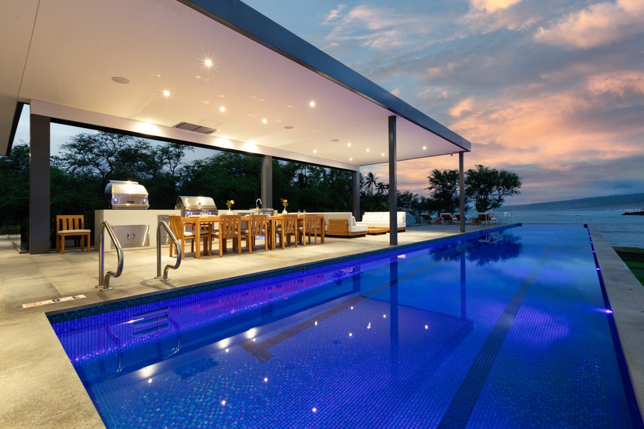 Kamuela Vacation Rentals, Puako’s Ocean Edge Modern Estate - Luxurious poolside dining and lanai area, perfect for evening entertainment.
