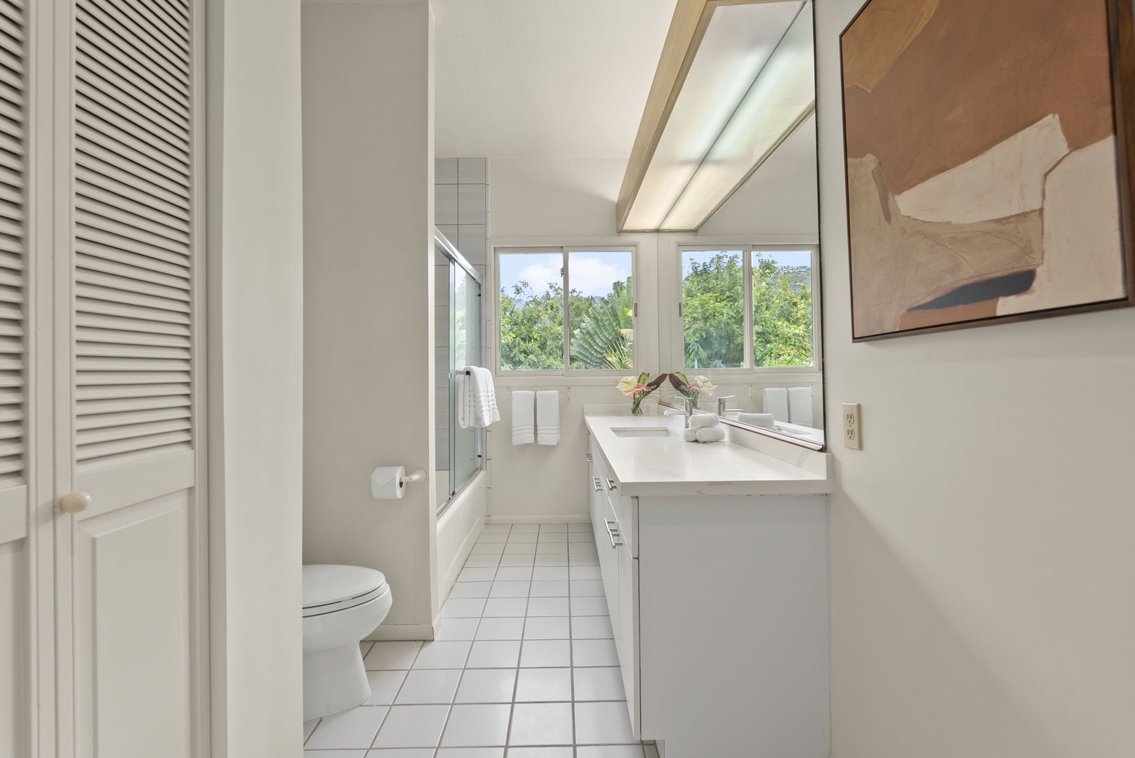 Honolulu Vacation Rentals, Paradise Beach Estate - This ensuite bathroom offers a traditional vanity, shower/tub combo, and wide mirrors—all framed by natural light.