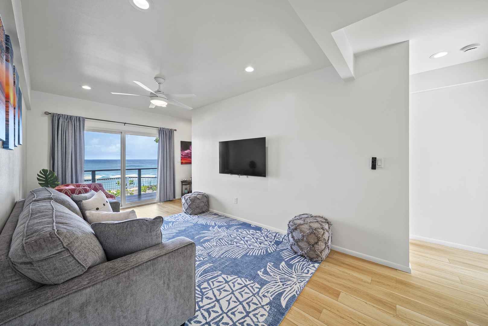 Haleiwa Vacation Rentals, Surfer's Paradise - Spacious downstairs lounge with ocean views—an inviting spot for relaxing, reading, or watching movies with the family. Sofa opens to queen bed.