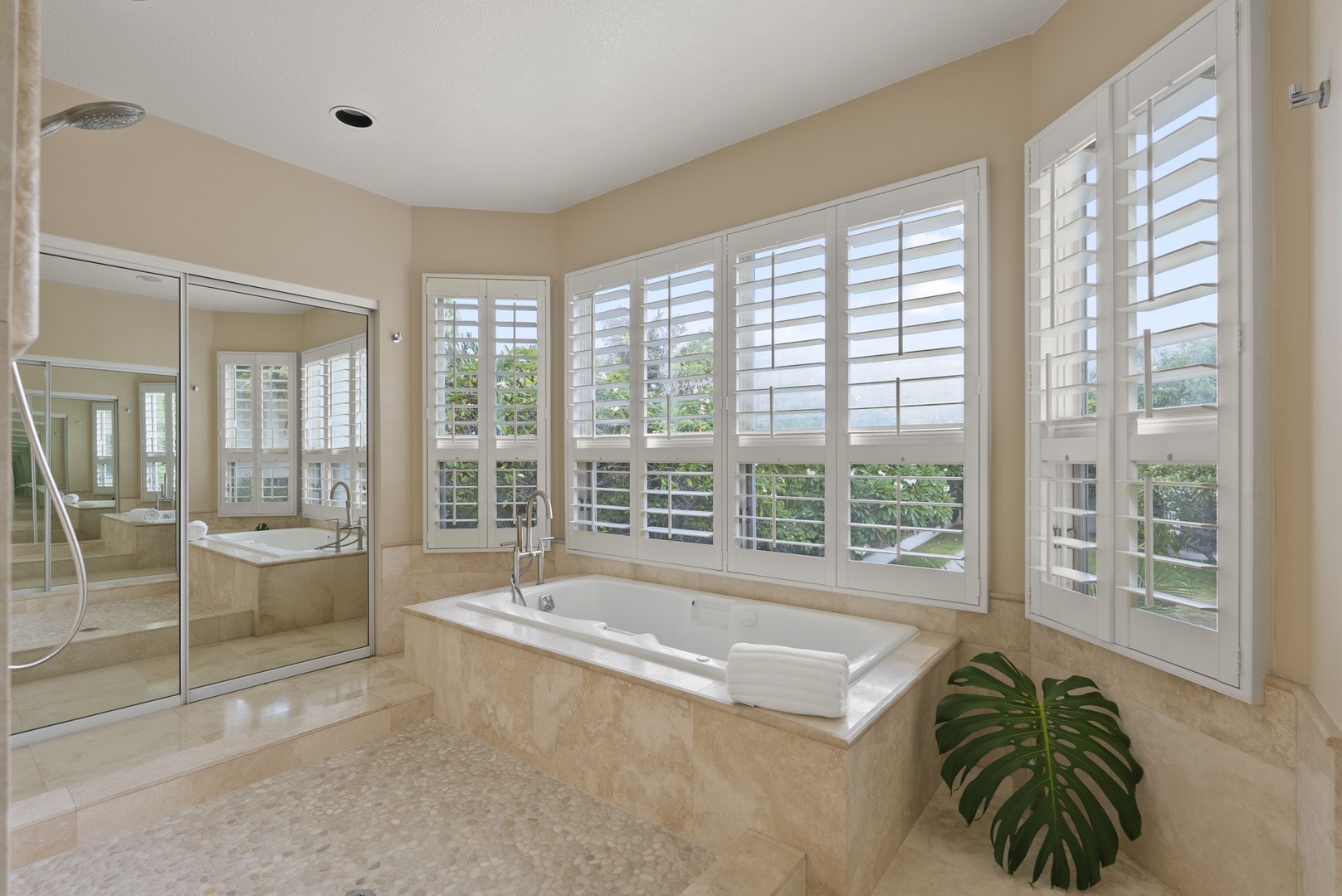 Honolulu Vacation Rentals, Paradise Beach Estate - Bask in the natural light from plantation shutters while soaking in this spa-style tub surrounded by elegant stone finishes.