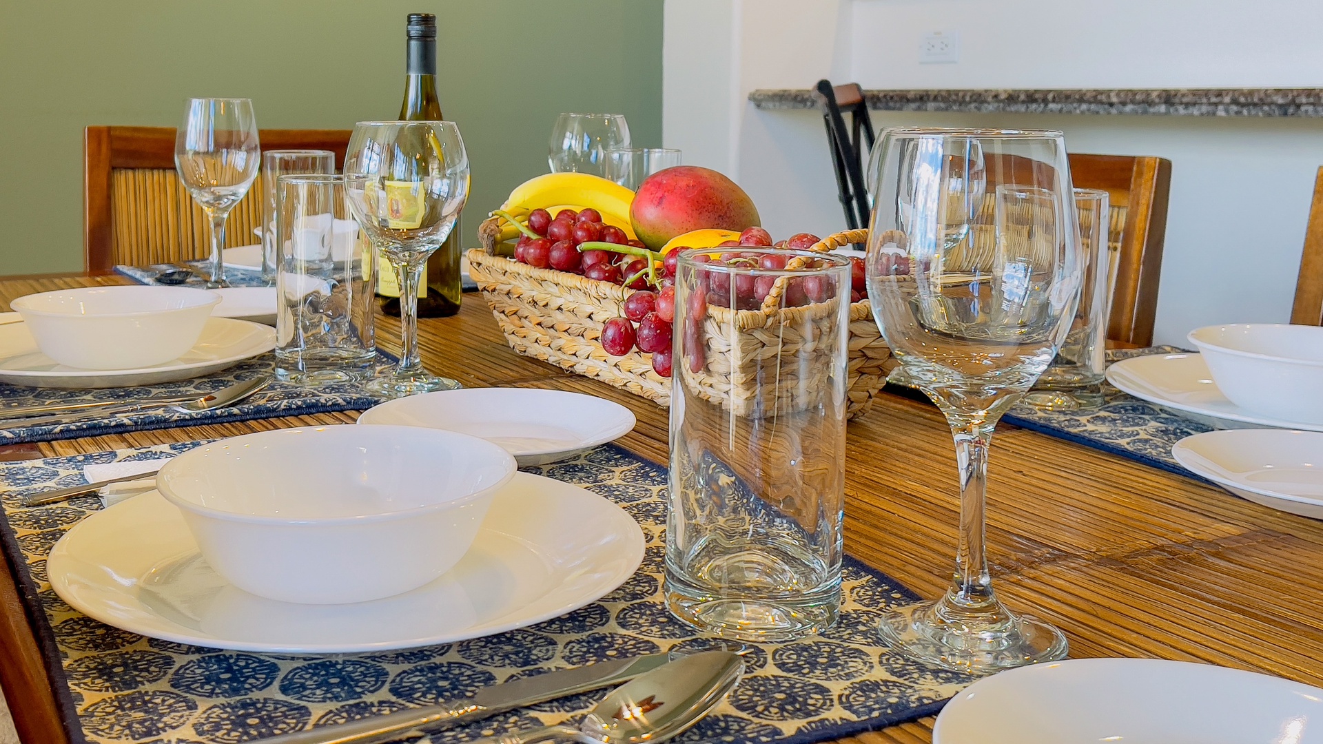 Waikoloa Vacation Rentals, Waikoloa Colony Villas 403 - Elegant dining setup with sparkling glassware and fresh fruit for a memorable meal.