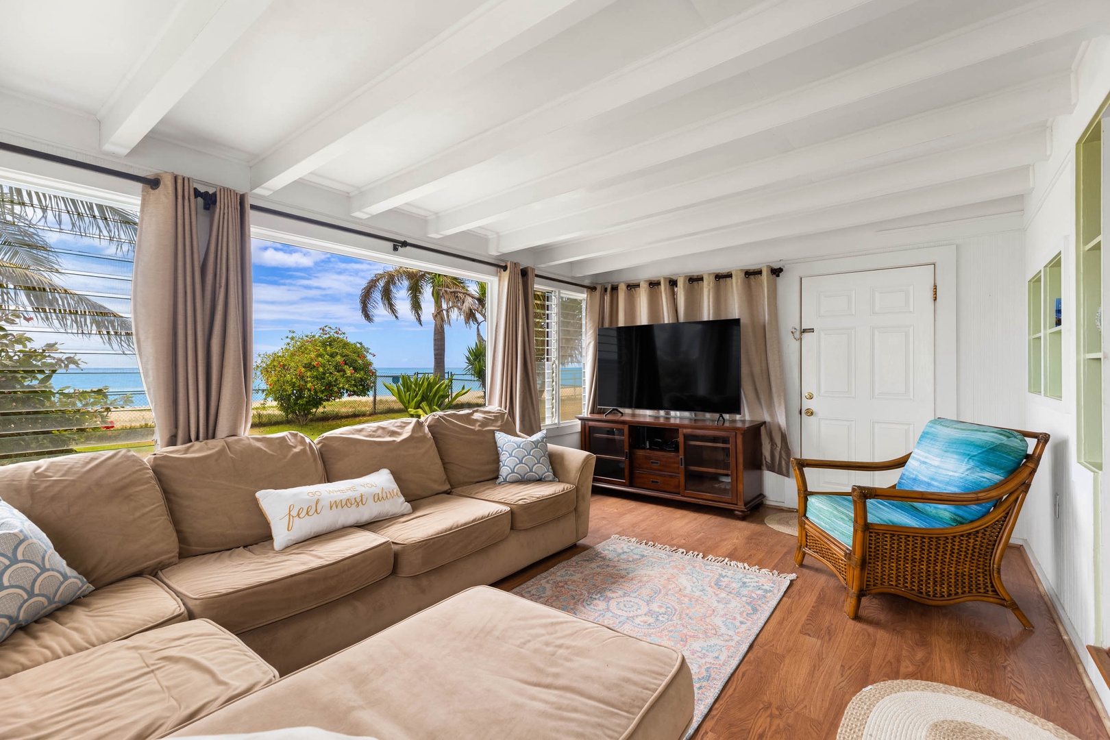 Ewa Beach Vacation Rentals, Ewa Beachfront Cottage - Cozy family den equipped with a plush sectional sofa and TV, perfect for binge-watching your favorite shows together.