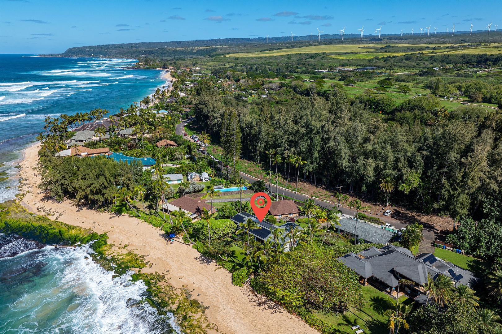 Haleiwa Vacation Rentals, Maluhia Beach House - Aerial view showcasing the home’s prime beachfront location, surrounded by lush greenery.