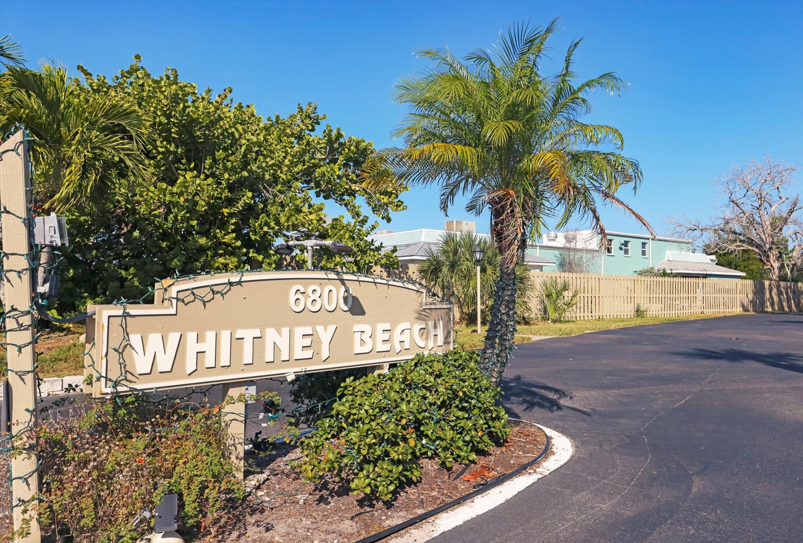 Whitney Beach property entrance with tropical landscaping and clear blue skies marking your arrival.