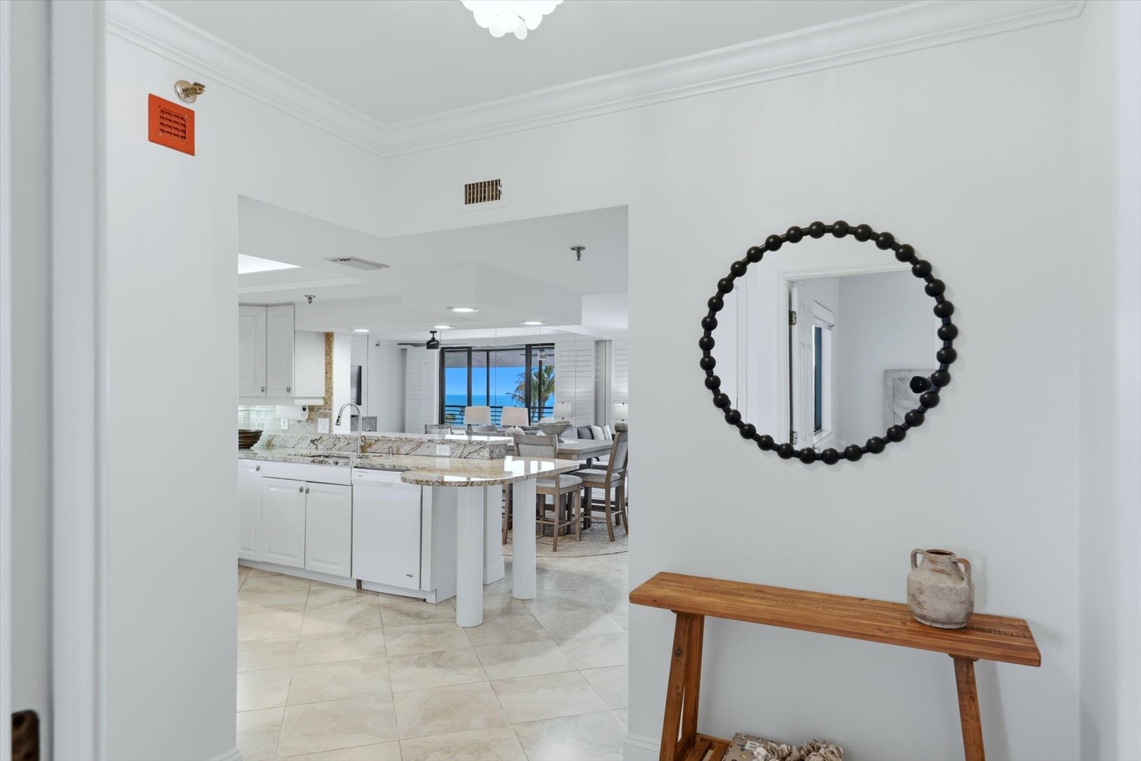 Step into your elegant coastal retreat, where modern white kitchen flows seamlessly into bright living spaces.