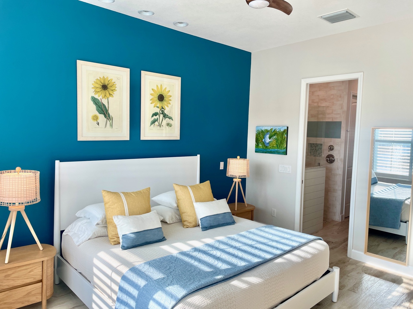 Drift off to sleep in this bright, cheerful bedroom where sunflower art and ocean-blue walls create your perfect coastal retreat.
