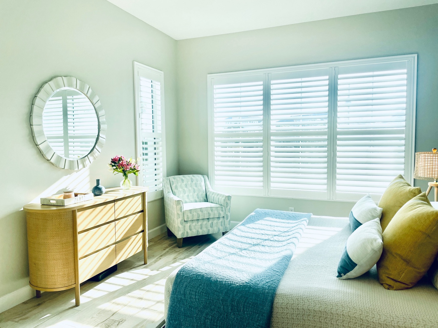 Drift into peaceful sleep in this serene bedroom, where soft mint walls and natural light create your perfect sanctuary.