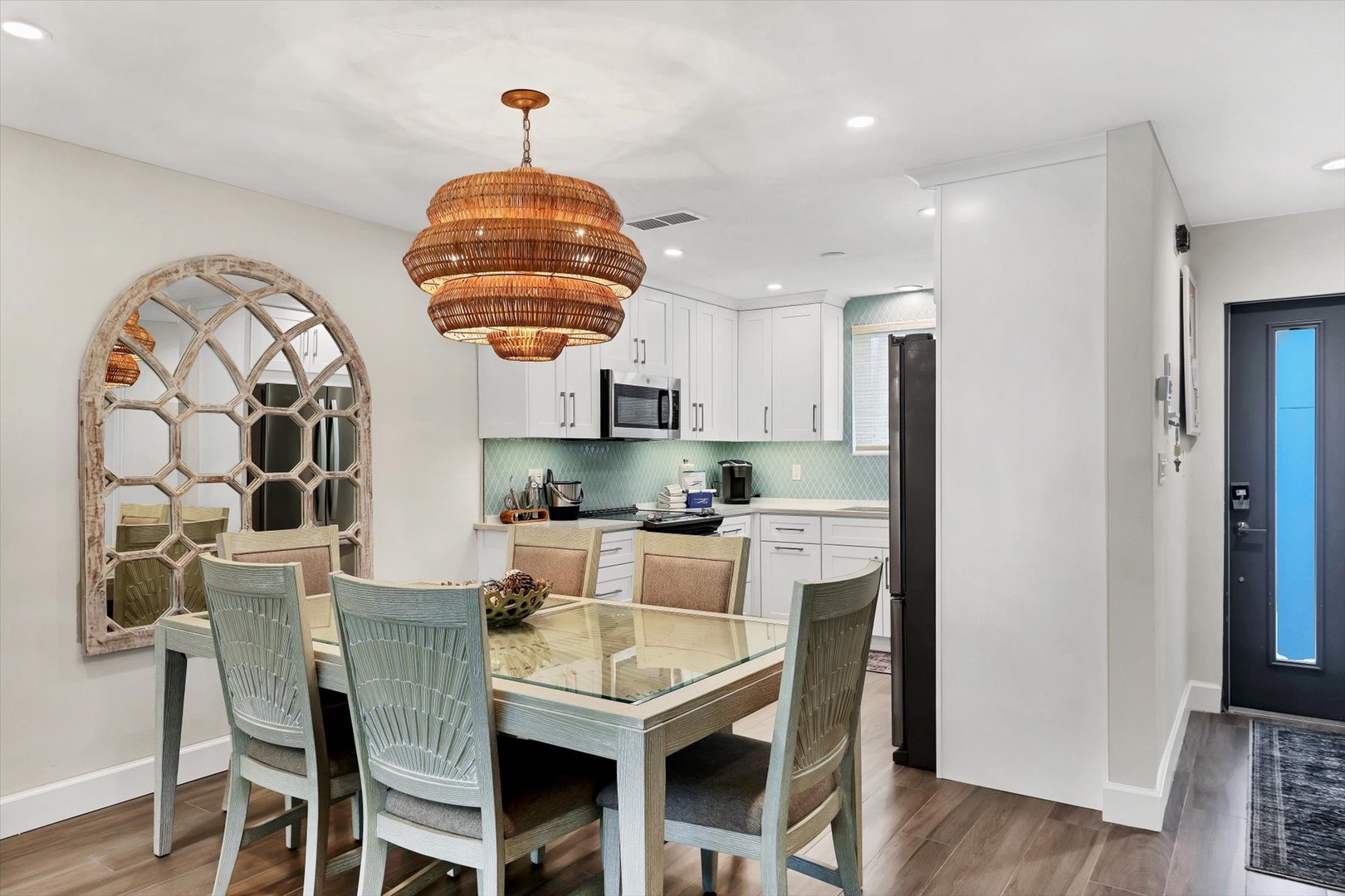 Your elegant dining space features coastal charm with a stunning woven chandelier casting warm light over meals shared with loved ones.