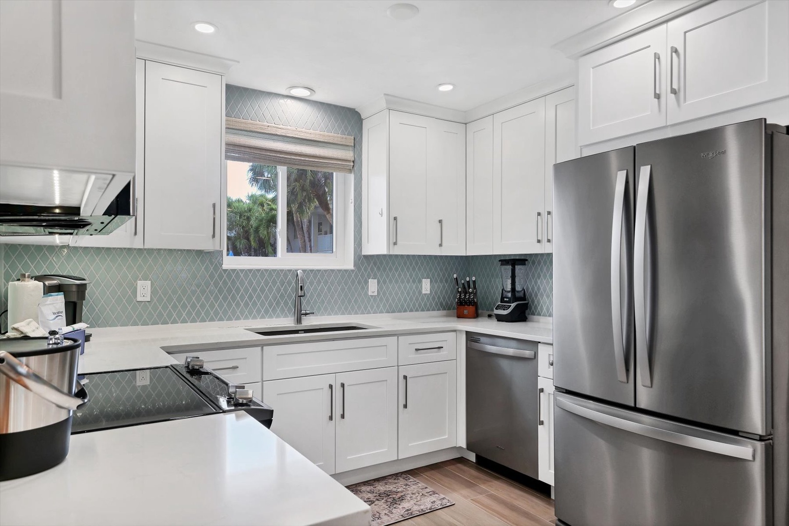 Cook your favorite meals in this bright, modern kitchen with white cabinets, stainless steel appliances, and elegant tiled backsplash.