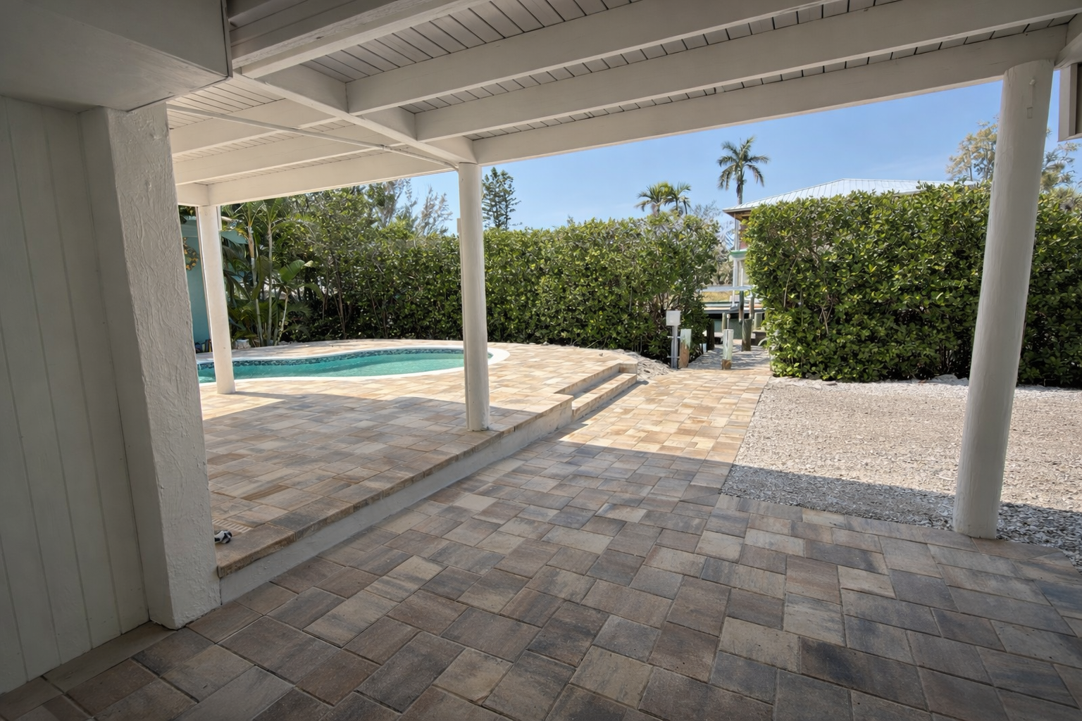 Relax under your private covered patio with beautiful stone flooring, overlooking the sparkling pool area surrounded by lush tropical landscaping.