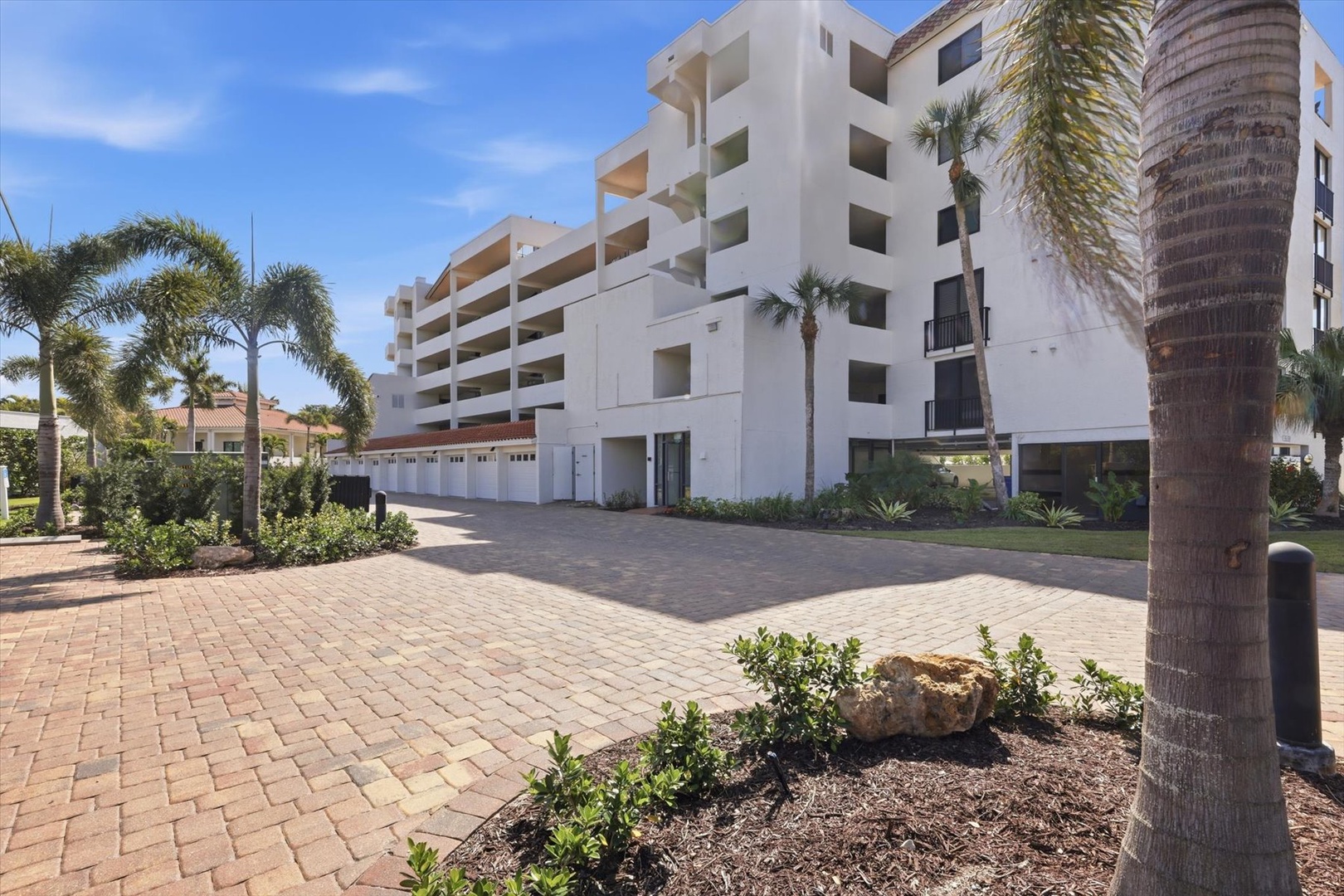 Modern tropical resort building with pristine landscaping and palm trees creates an inviting arrival experience.