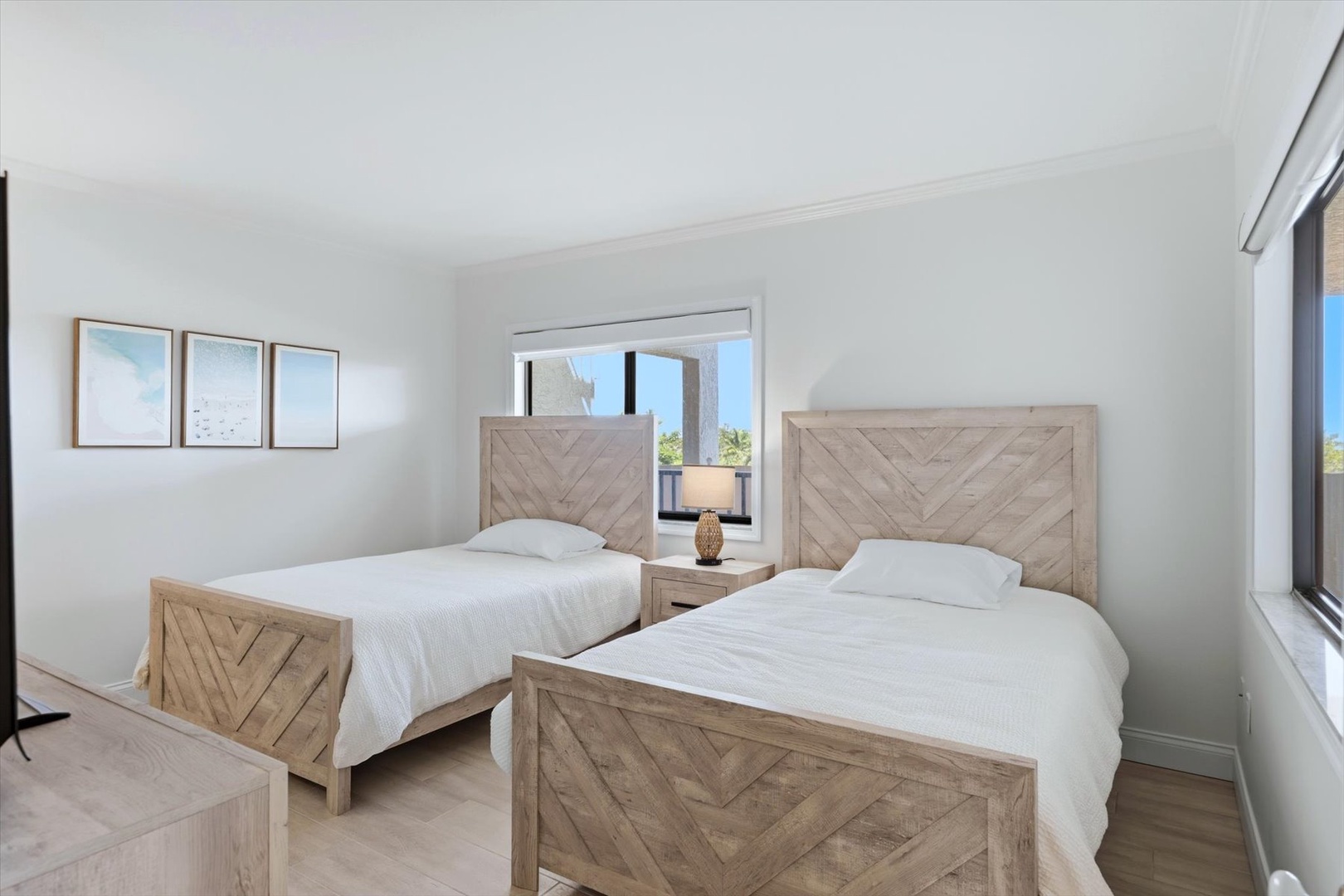 Your bright twin bedroom offers comfort and style with rustic wooden beds and peaceful views through large windows.