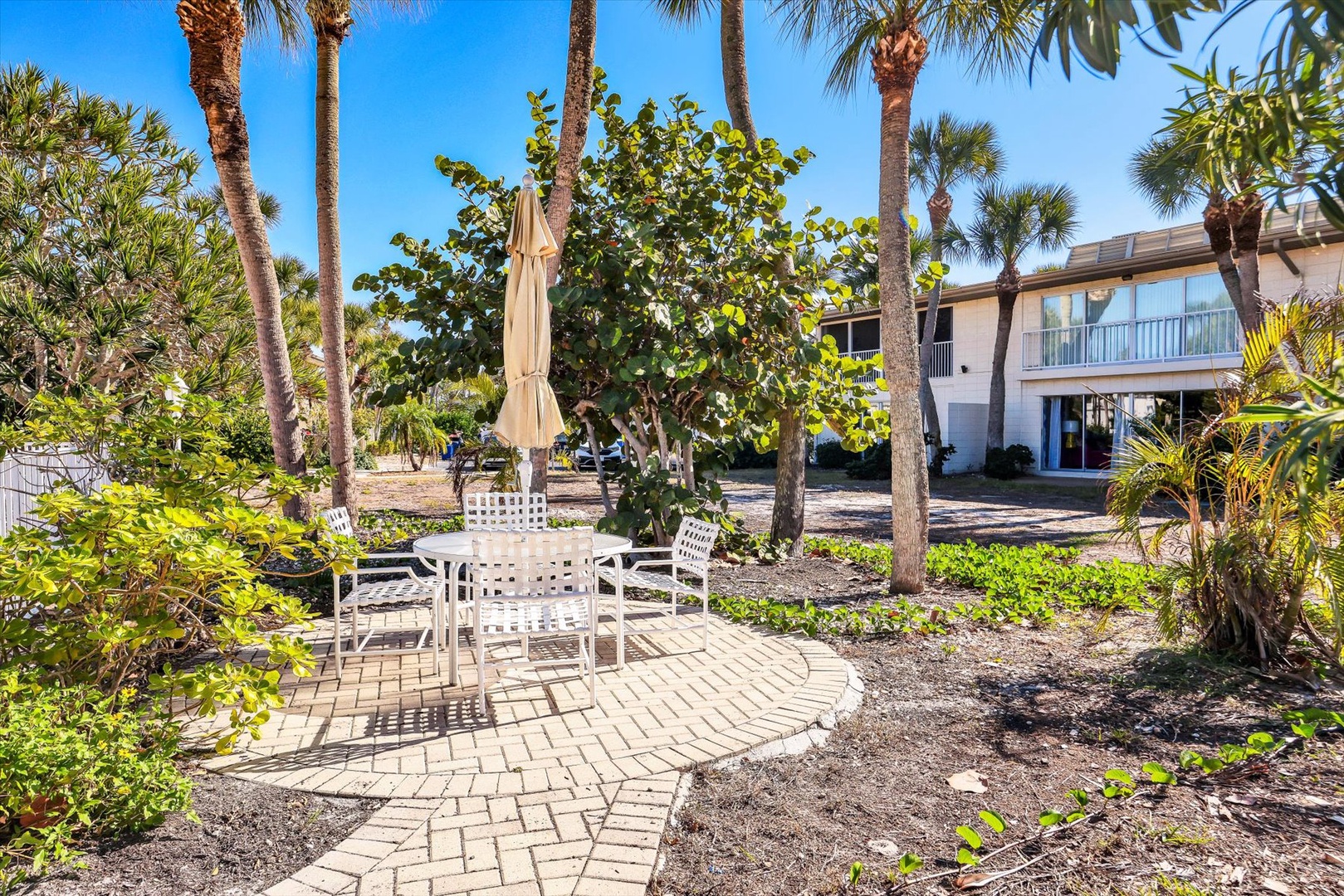 Tropical paradise awaits with lush palm trees, private patio dining, and your coastal retreat perfectly positioned among native landscaping.