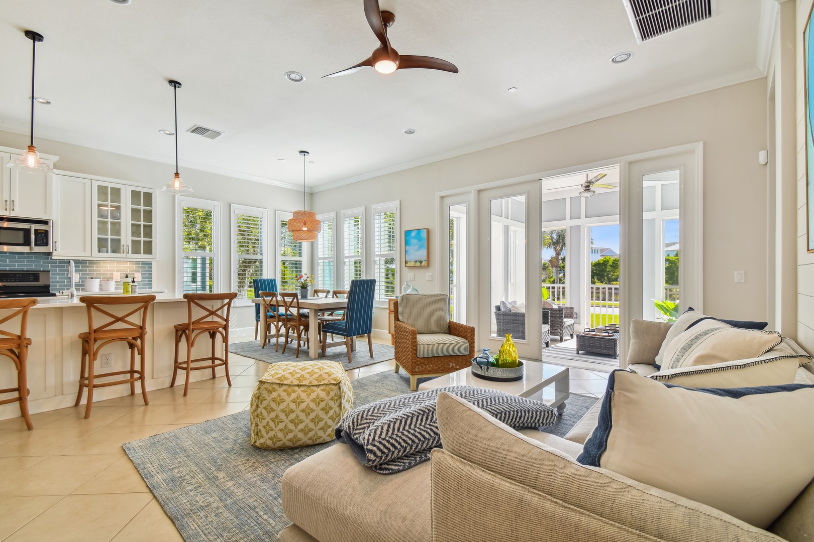 Relax in your stylish open-concept living space featuring coastal-inspired furnishings, modern kitchen, and dining area flowing onto your private outdoor patio.