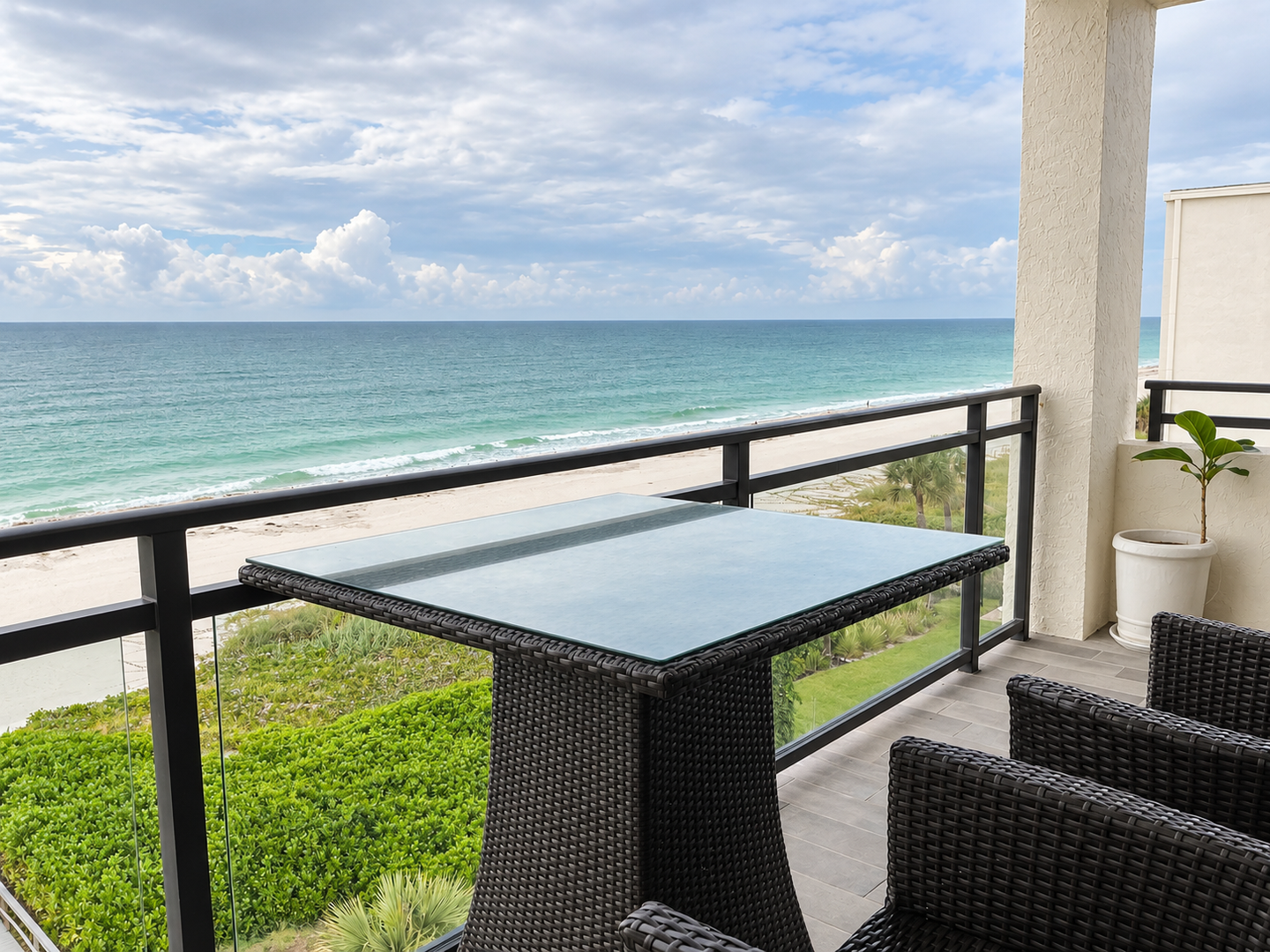 Bright beachfront balcony overlooking a cloudy ocean