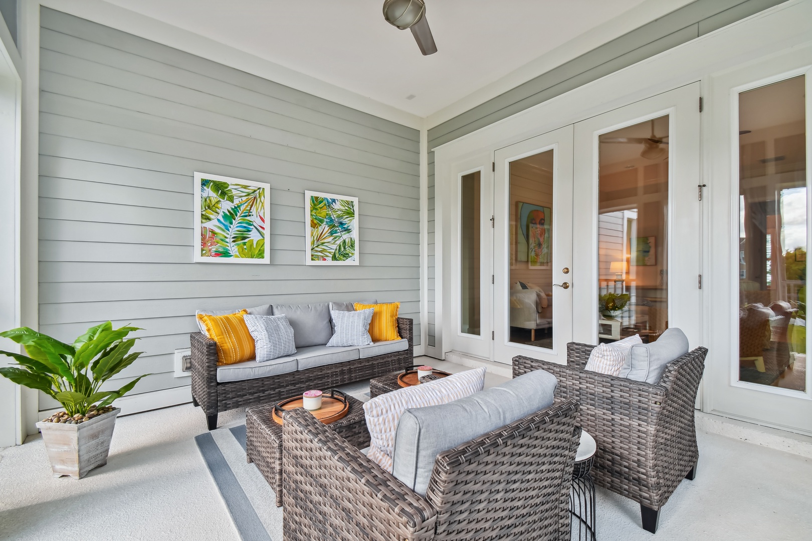 Unwind on your private covered patio with plush wicker seating and tropical artwork, where cool breezes complement your morning coffee ritual.