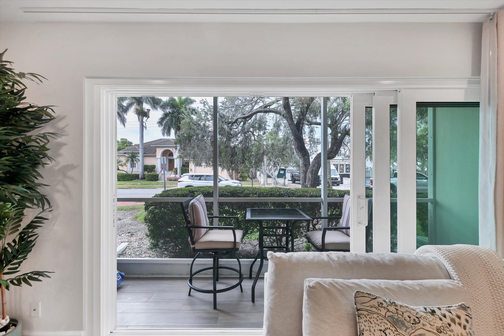 Step onto your private patio through sliding doors where comfortable seating awaits amid peaceful neighborhood views.