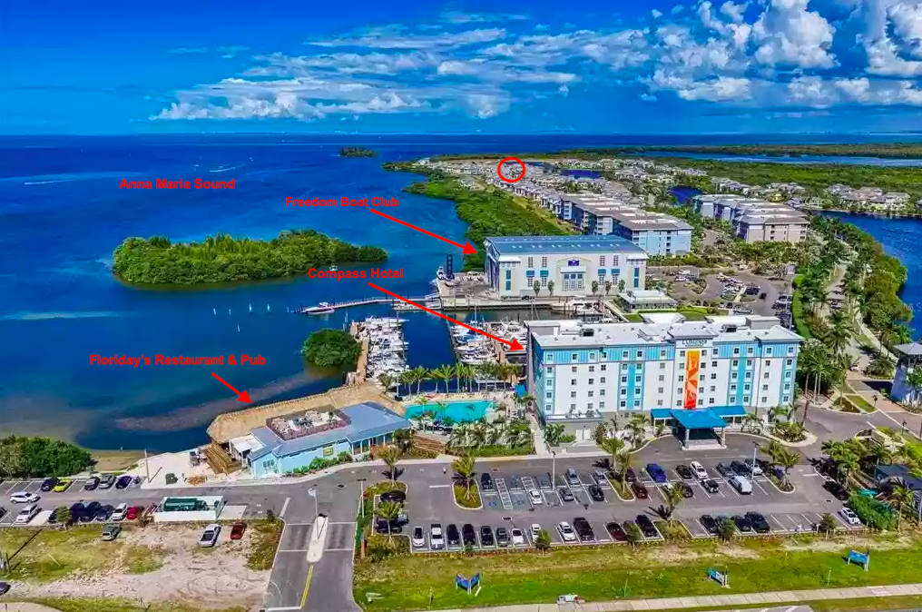 Aerial view of the waterfront property situated along pristine Caribbean coastline with nearby marina and dining facilities.
