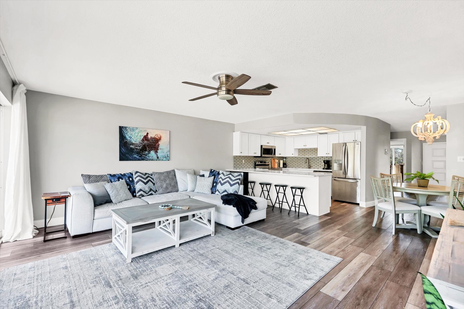 Relax in your bright, open-concept space where modern comfort meets coastal style. Plush sectional seating flows into a fully equipped kitchen.
