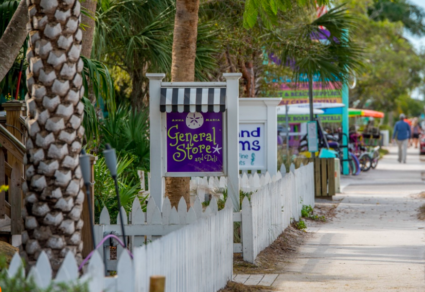 Charming tropical street with local shops and palm trees creating a relaxed island atmosphere for exploring.