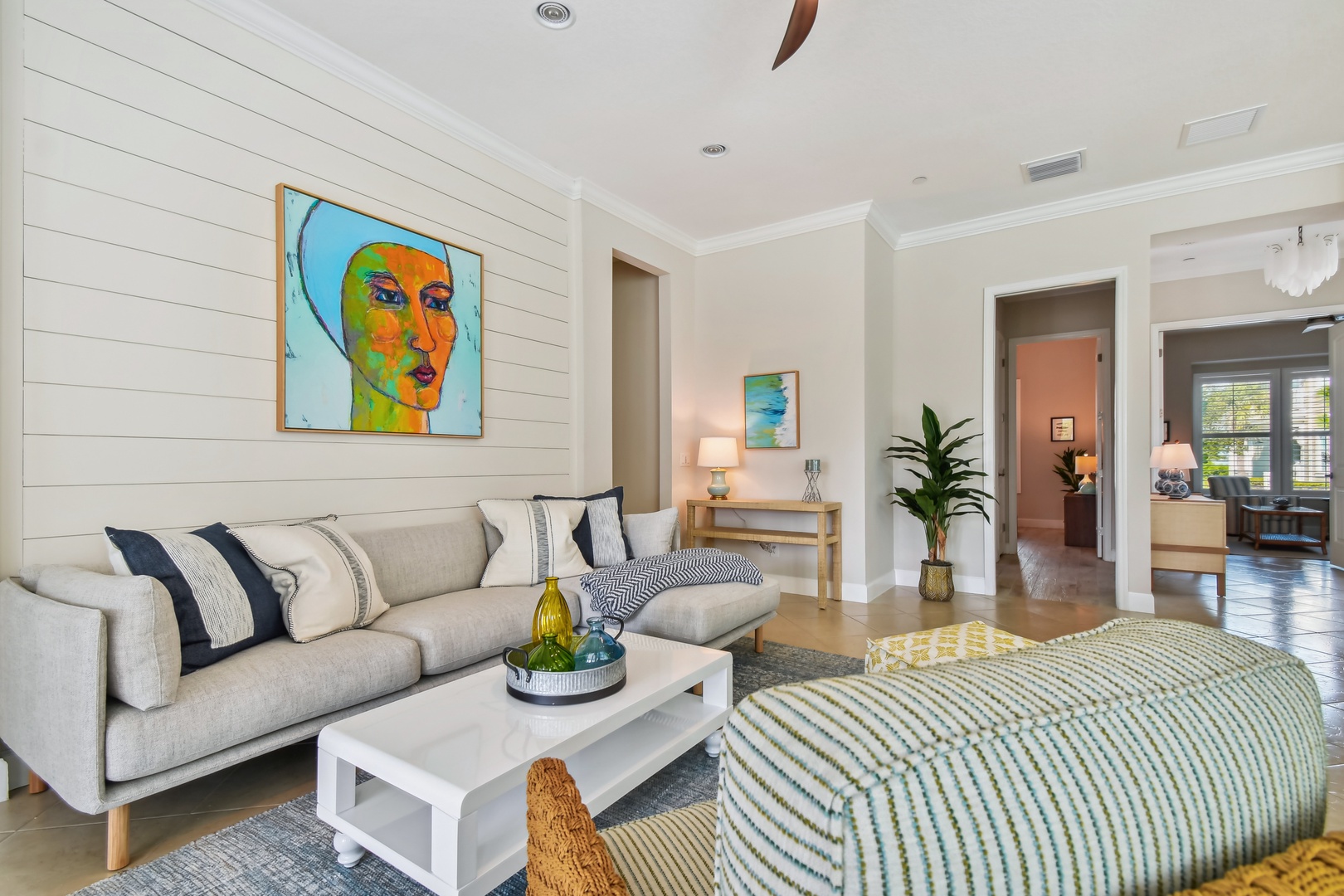 Sink into your stylish living room's plush sofa, surrounded by vibrant art and natural light streaming through open spaces.