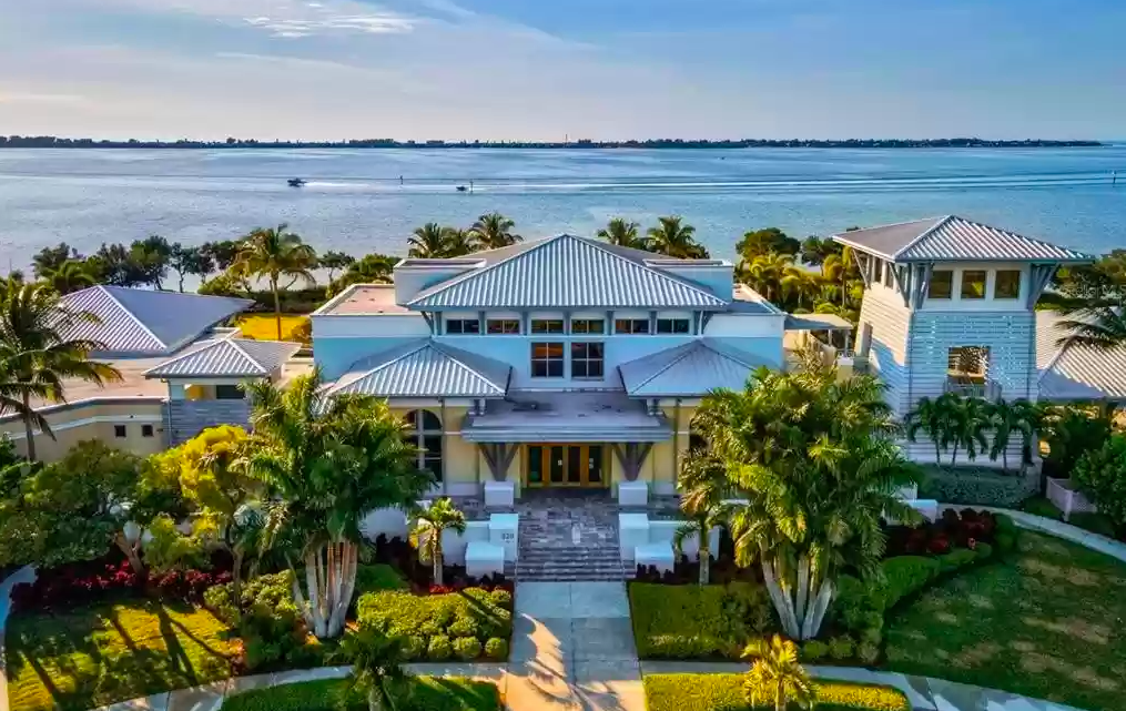 Stunning waterfront estate with tropical landscaping and expansive bay views creating the perfect island getaway backdrop.