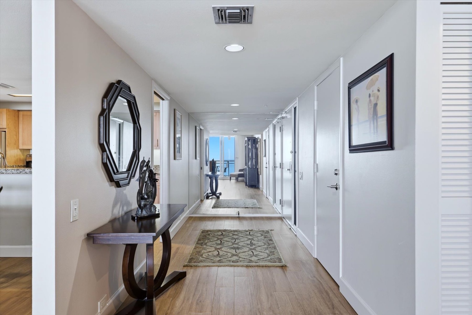 Bright hallway leads you toward stunning ocean views, with polished floors and elegant touches creating a welcoming arrival.