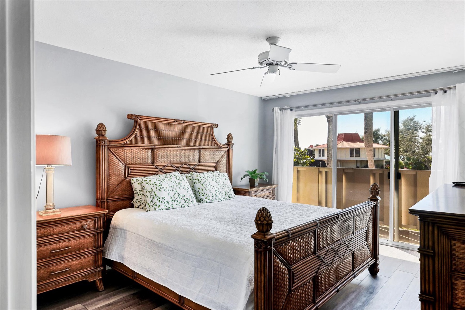 Drift off in your tropical-inspired bedroom with stunning wicker furniture and bright balcony views that invite peaceful mornings.