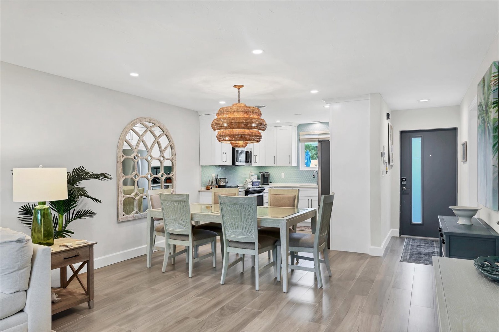 Gather around your elegant dining table in this beautifully appointed open-concept space featuring coastal-inspired decor and modern kitchen.