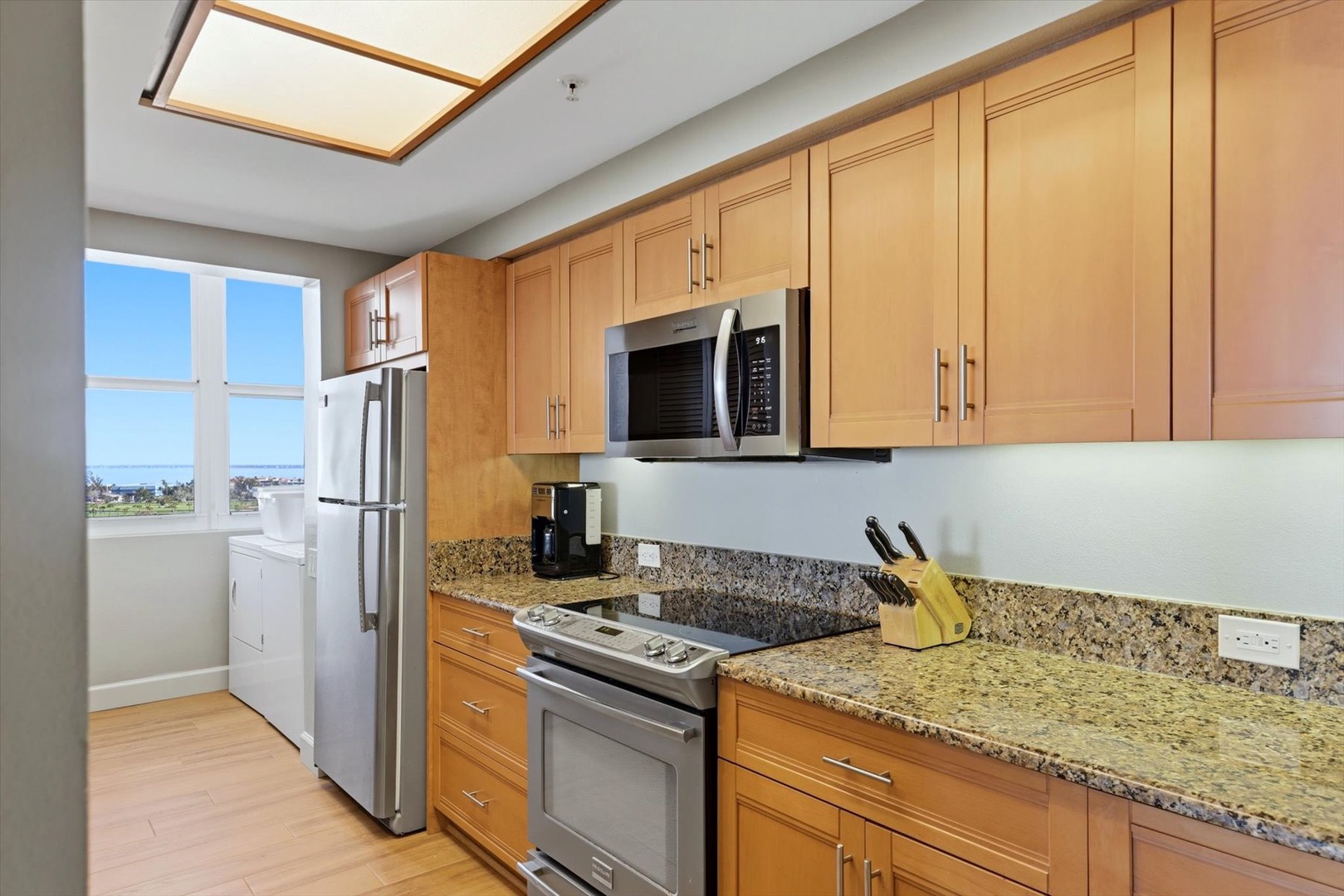 Your fully-equipped kitchen awaits with granite counters, stainless steel appliances, and a skylight that fills the space with natural light while you cook.