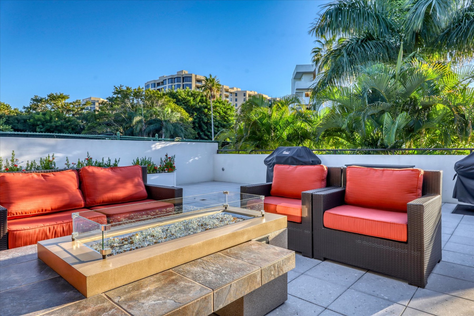 Gather around your private fire table on this stunning rooftop terrace, surrounded by vibrant coral cushions and tropical views.