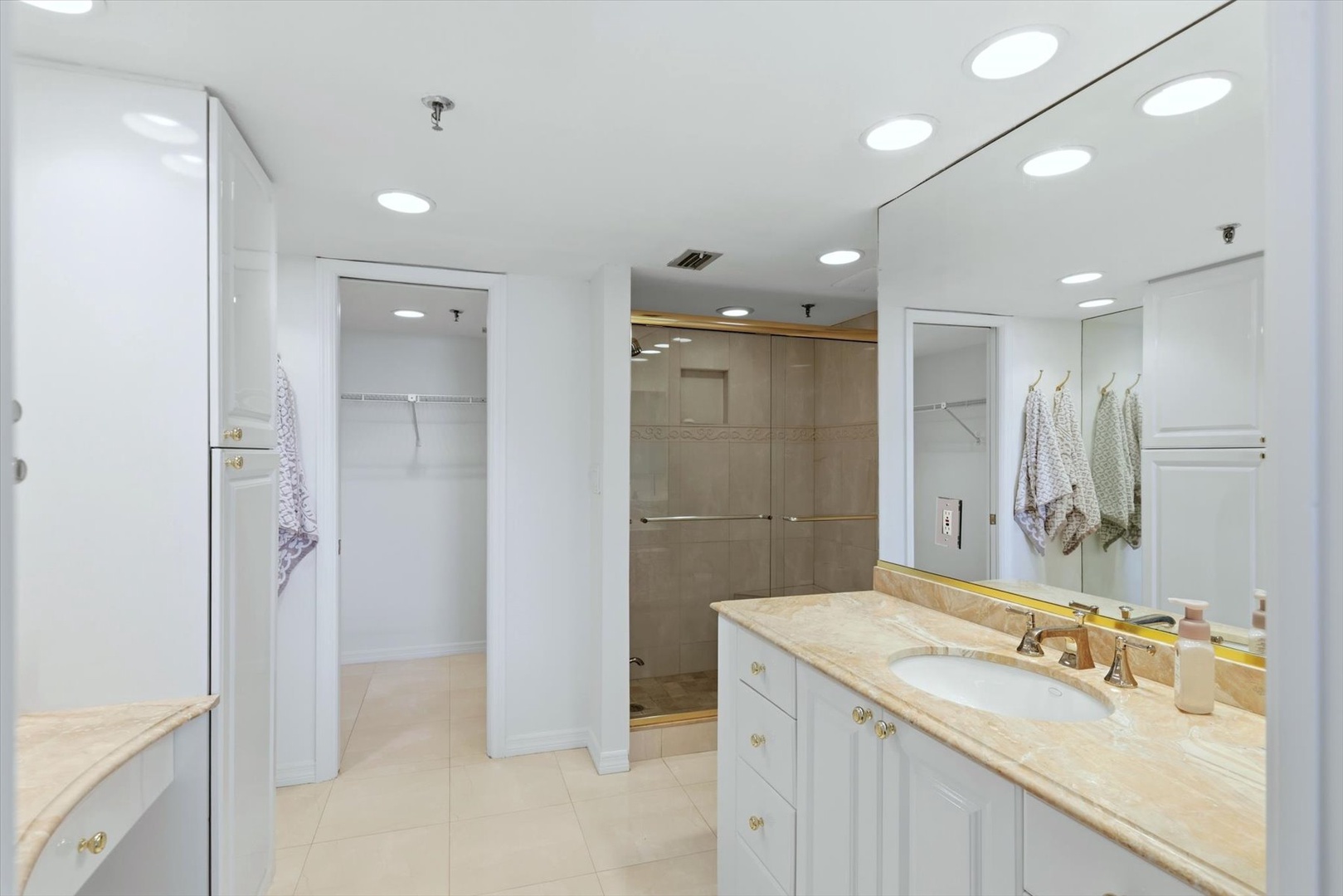 Step into your elegant master bathroom with dual vanities, luxurious marble countertops, and a spacious glass shower—your personal spa awaits.