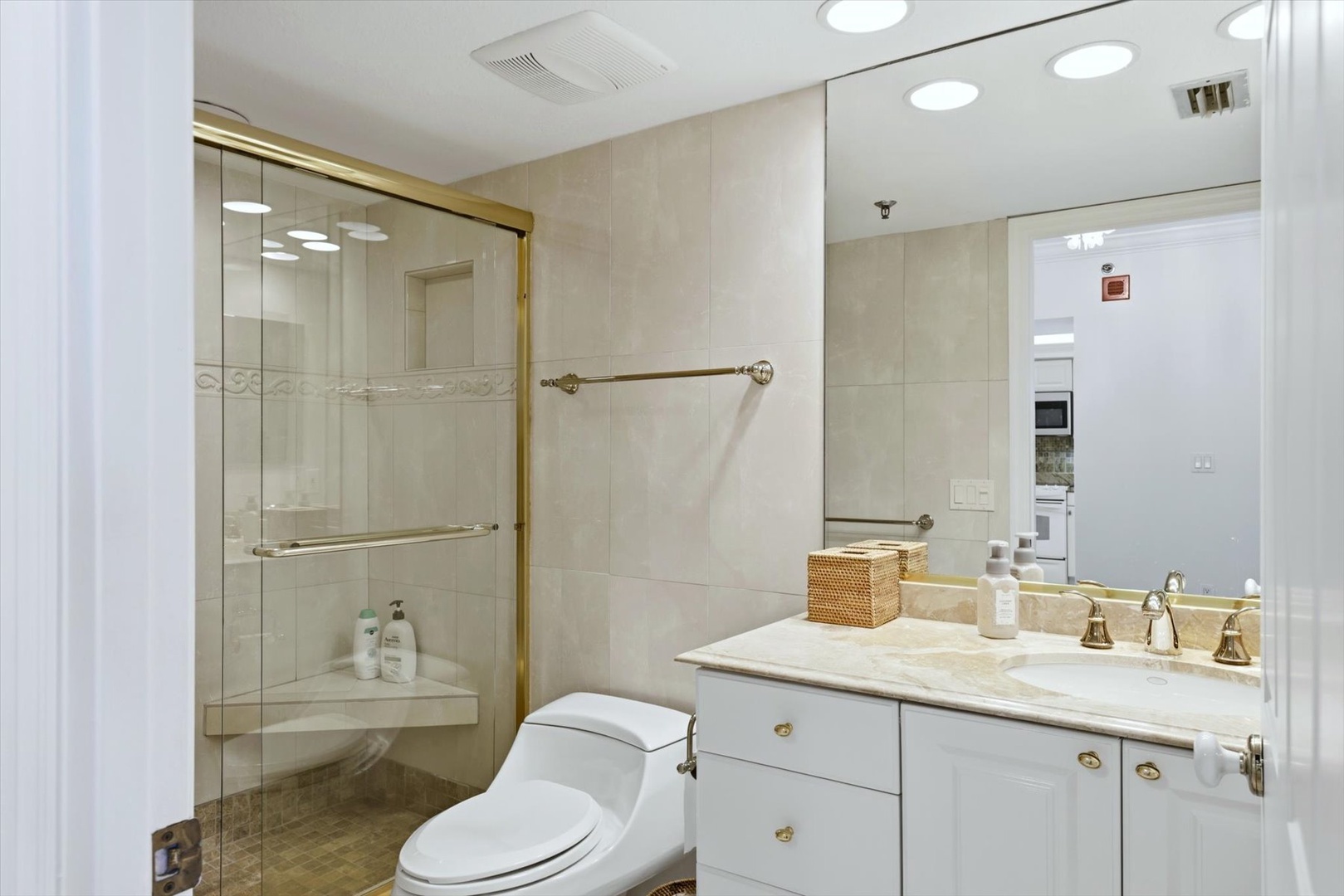 Step into your pristine marble bathroom with gold accents, walk-in shower, and thoughtful amenities for a luxurious daily routine.