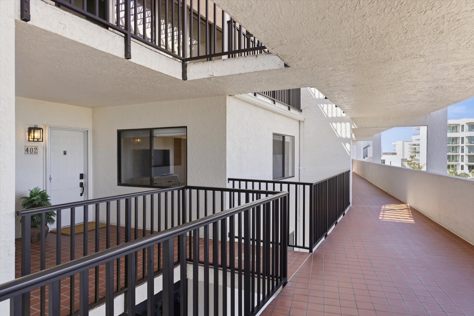 Step onto your private balcony walkway where morning light filters through, creating a peaceful entrance to your retreat.