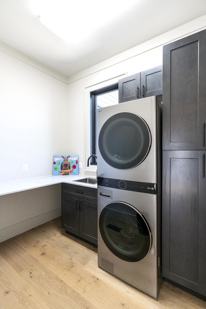 Your dedicated laundry room features modern stacked washer and dryer with ample counter space for folding clothes.