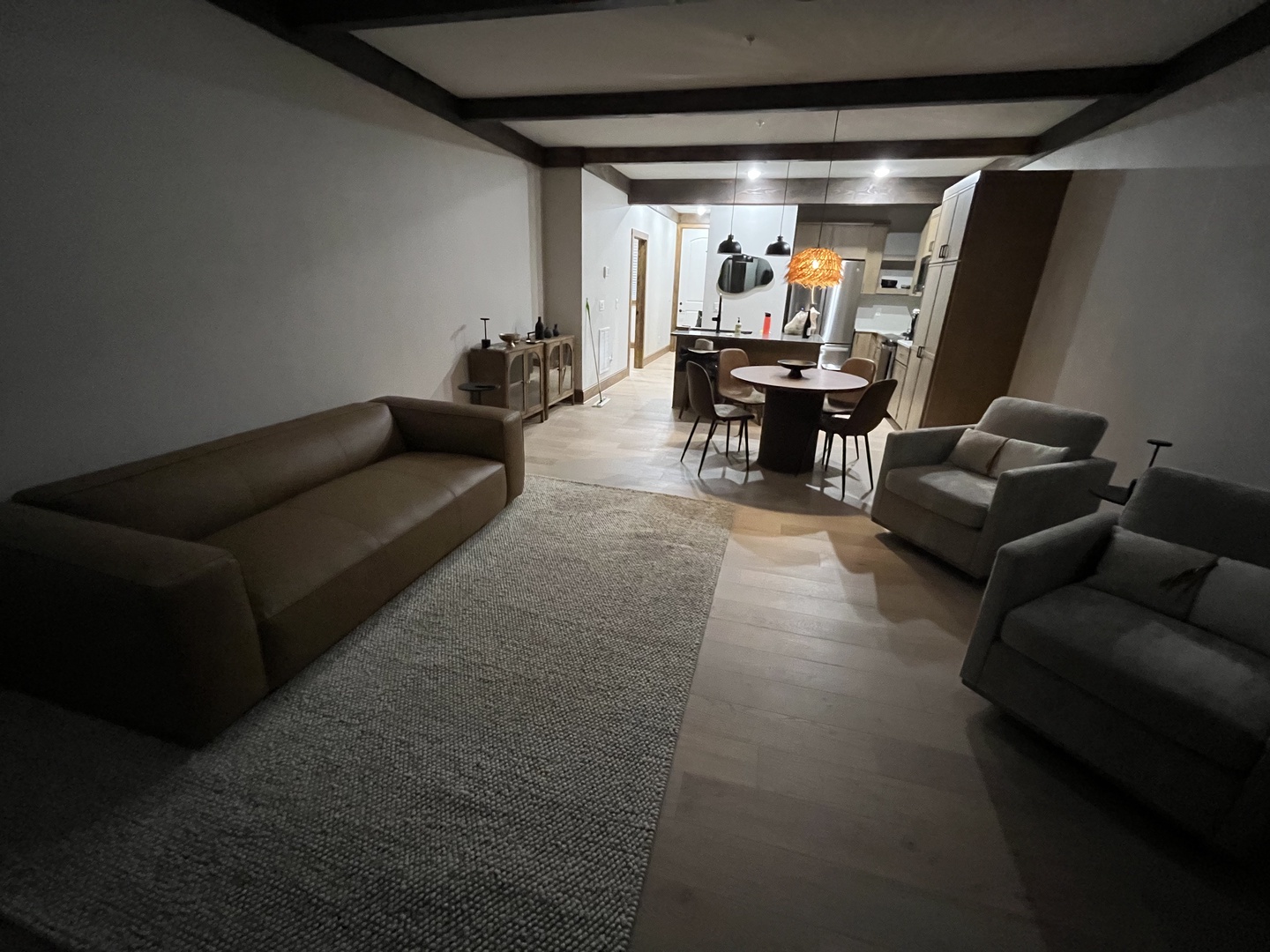 Settle into your spacious living area with modern furnishings and exposed beams, where your open-plan layout flows seamlessly into the dining space and fully-equipped kitchen.