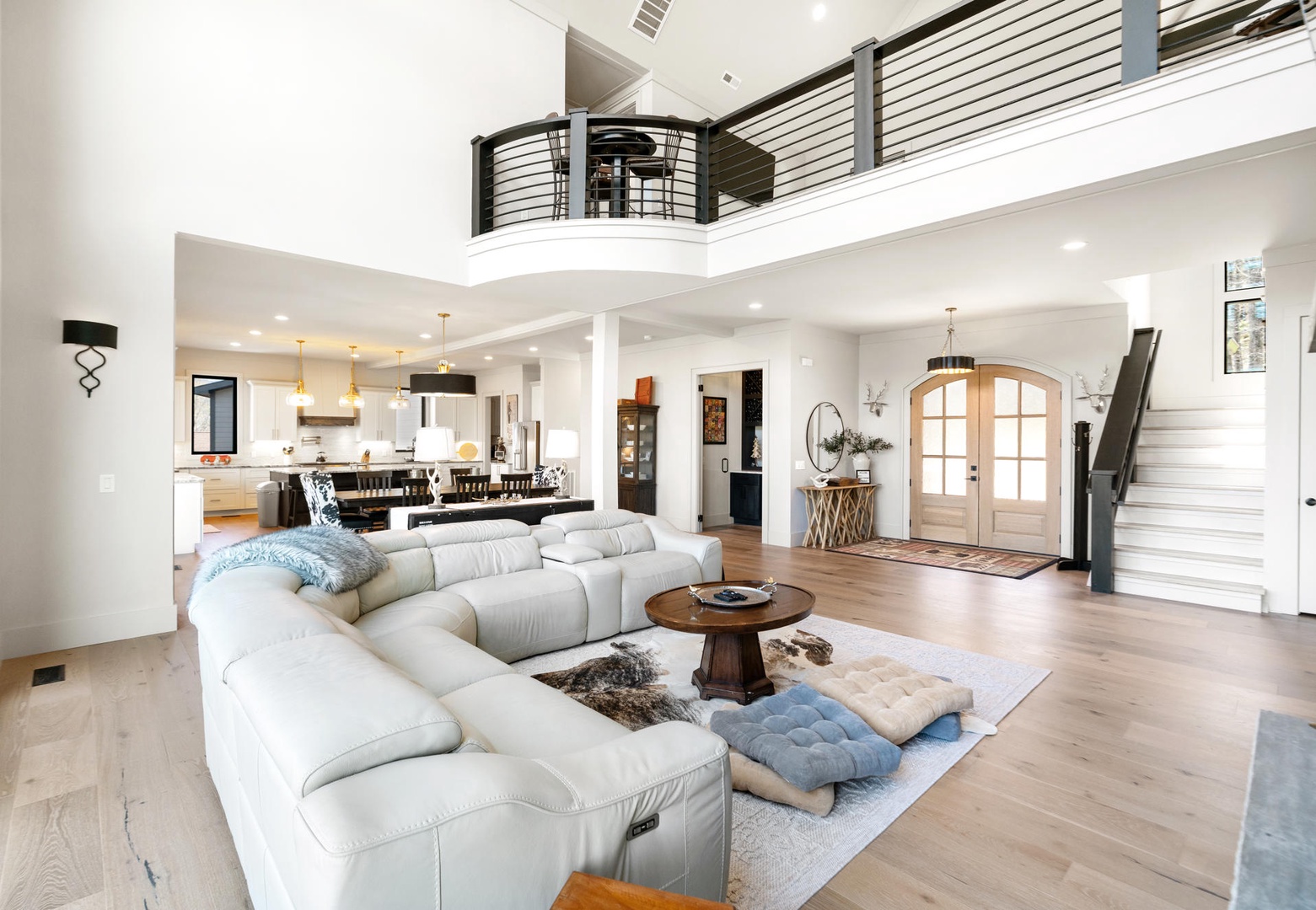 Unwind in your spacious open-concept living room featuring soaring ceilings, plush sectional seating, and modern design that flows seamlessly into the gourmet kitchen.