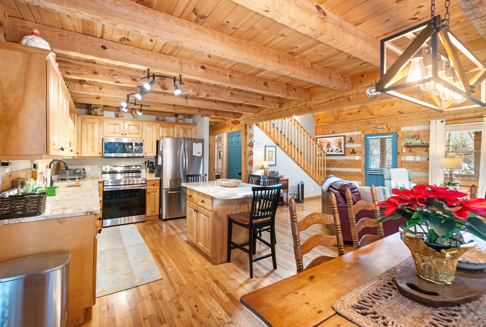 Warm wood beams frame your cozy mountain retreat where rustic charm meets modern comfort in this open-concept haven.