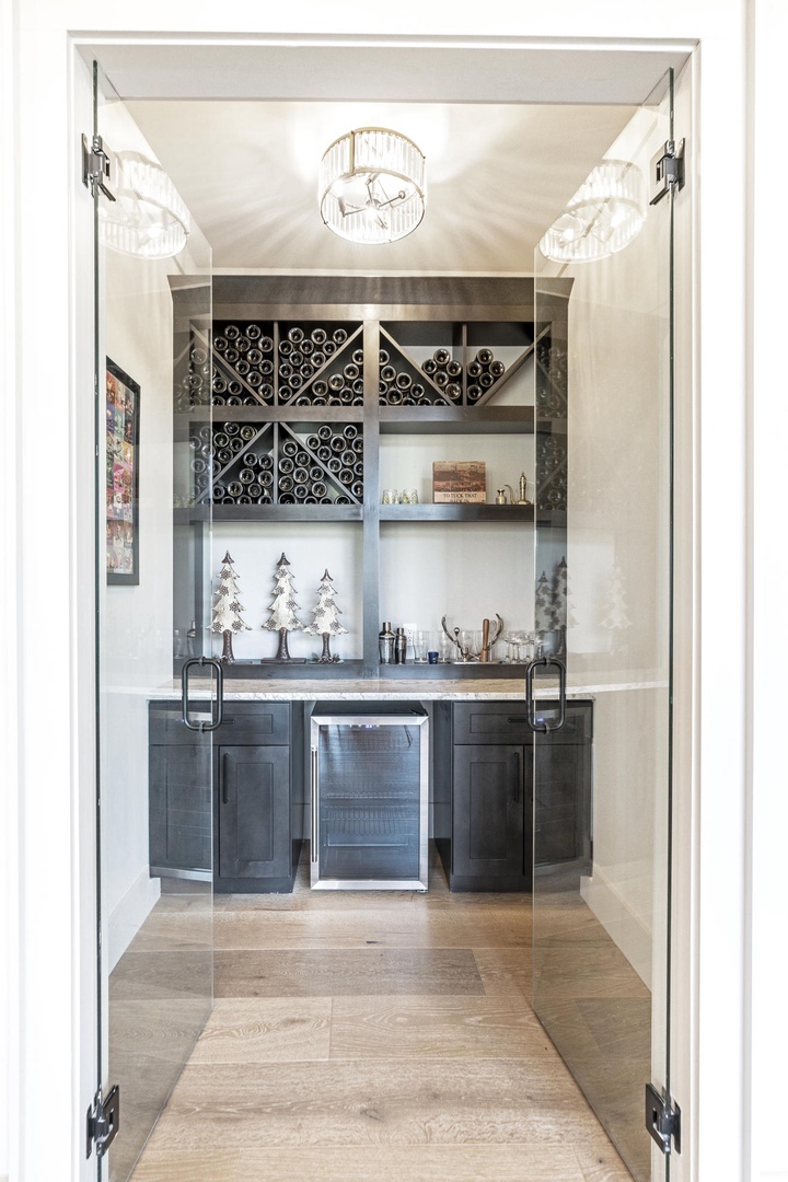 Your private bar awaits with elegant wine storage and gleaming fixtures—perfect for crafting cocktails while entertaining guests.