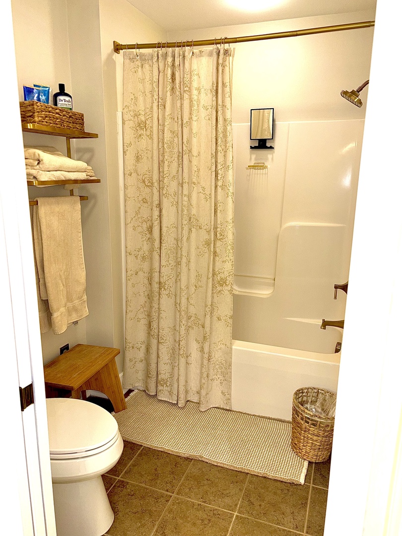 Private en-suite bath with dual vanities and warm, updated finishes.