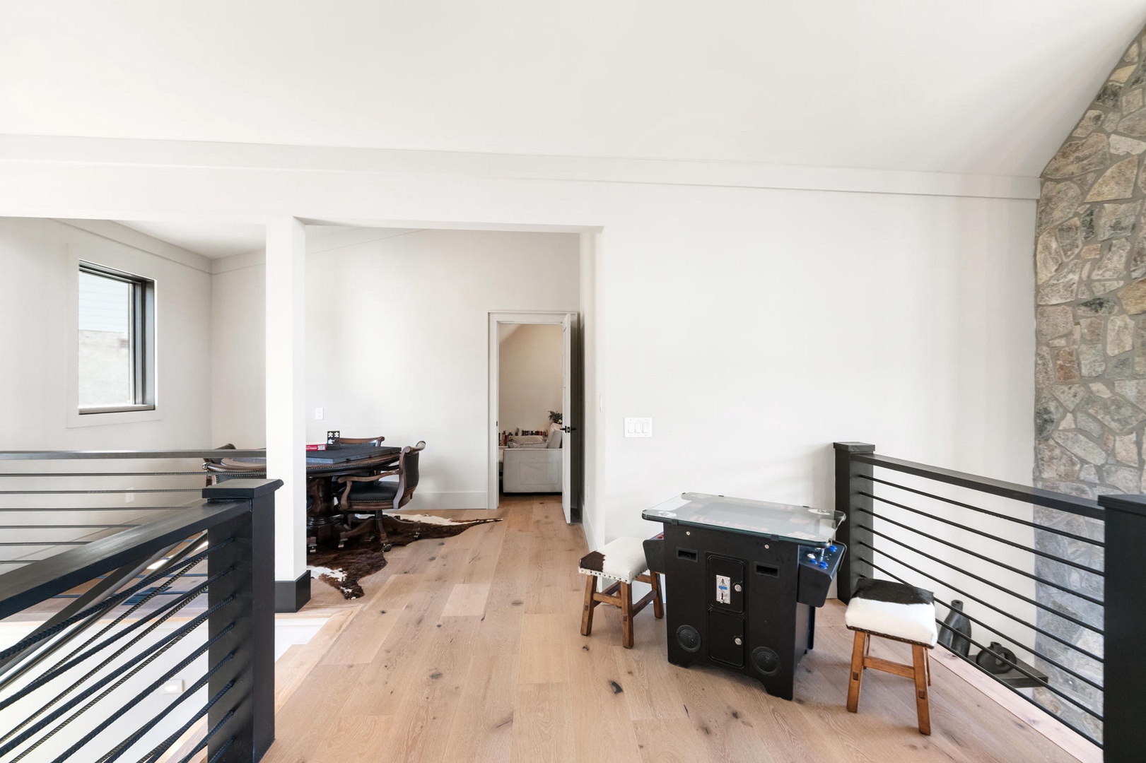Warm hardwood floors and natural lighting accent the loft area set up for games and family fun!