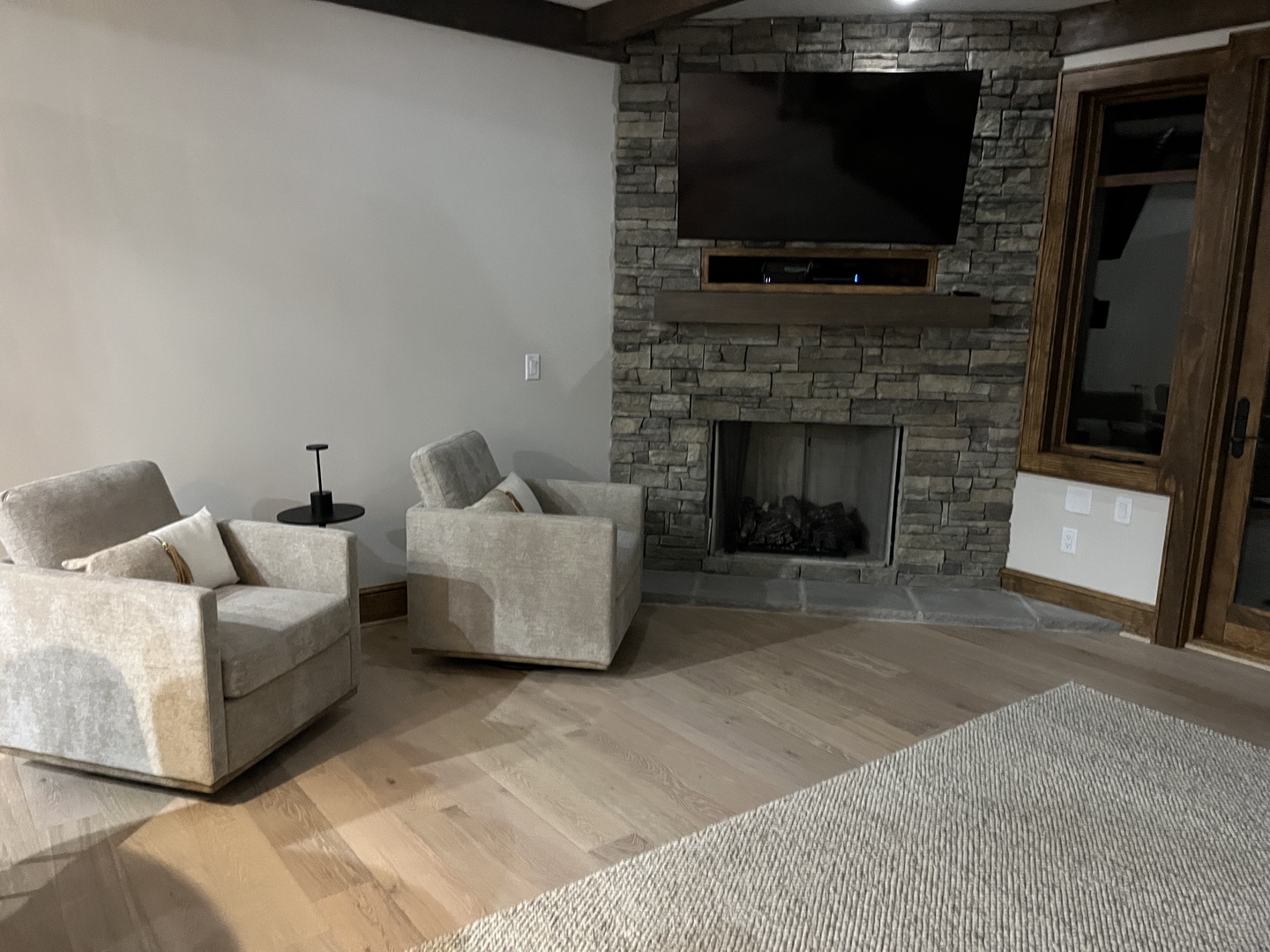 Unwind in your cozy living space, complete with plush seating and a handsome stone fireplace to set the perfect mood for relaxation.