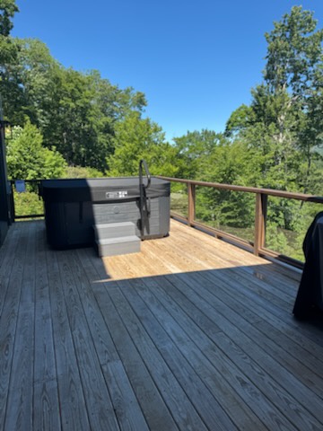 A private deck surrounded by lush greenery, perfect for morning coffee or evening relaxation with your favorite people. The outdoor space includes a grill for impromptu cookouts under open skies.