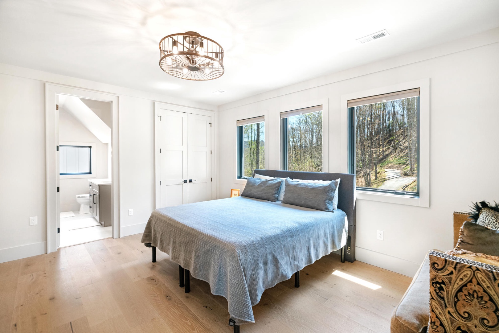 Your serene bedroom sanctuary features panoramic forest views and an elegant ceiling fan to keep you comfortable year-round. King size bed, upstairs.