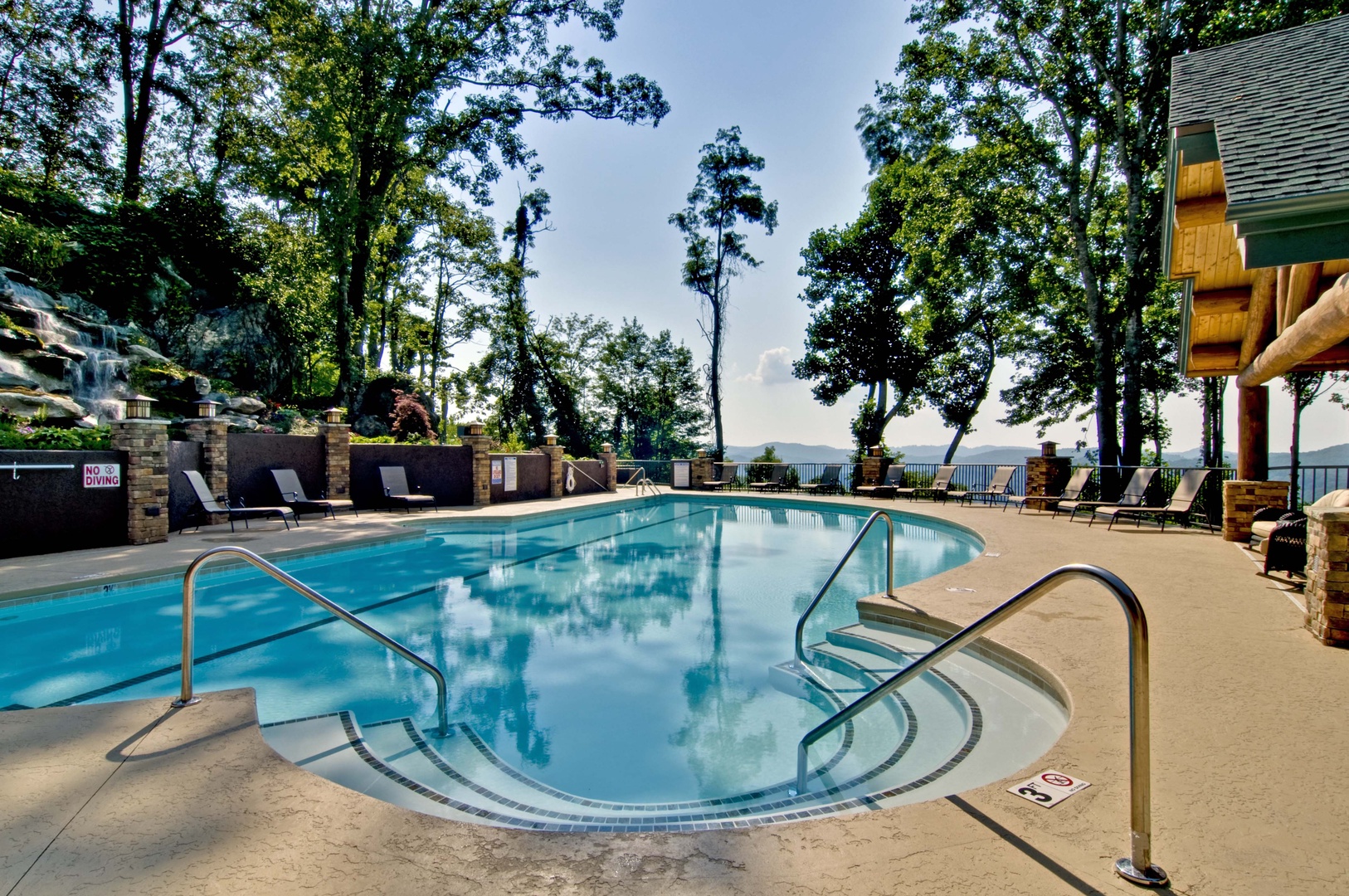 A sparkling outdoor pool set among towering trees, with poolside loungers and scenic mountain views beyond. Perfect for sunny afternoons and peaceful relaxation.