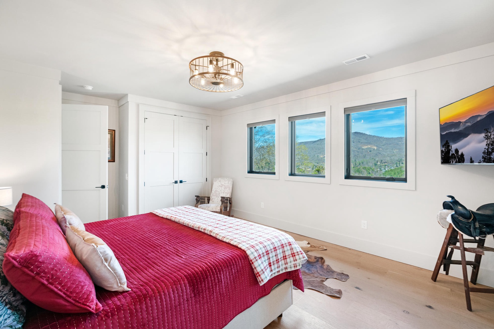 Wake up to stunning mountain vistas through your bedroom's picture windows, where crisp morning light fills this peaceful retreat.