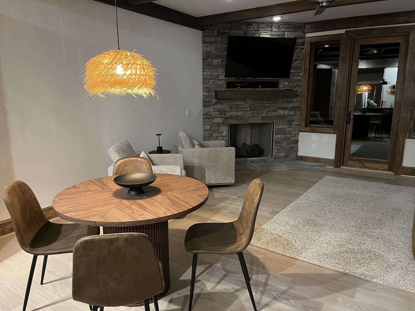 Unwind in your open-concept living space, where natural wood tones and a cozy stone fireplace create a warm mountain retreat perfect for evenings with loved ones.