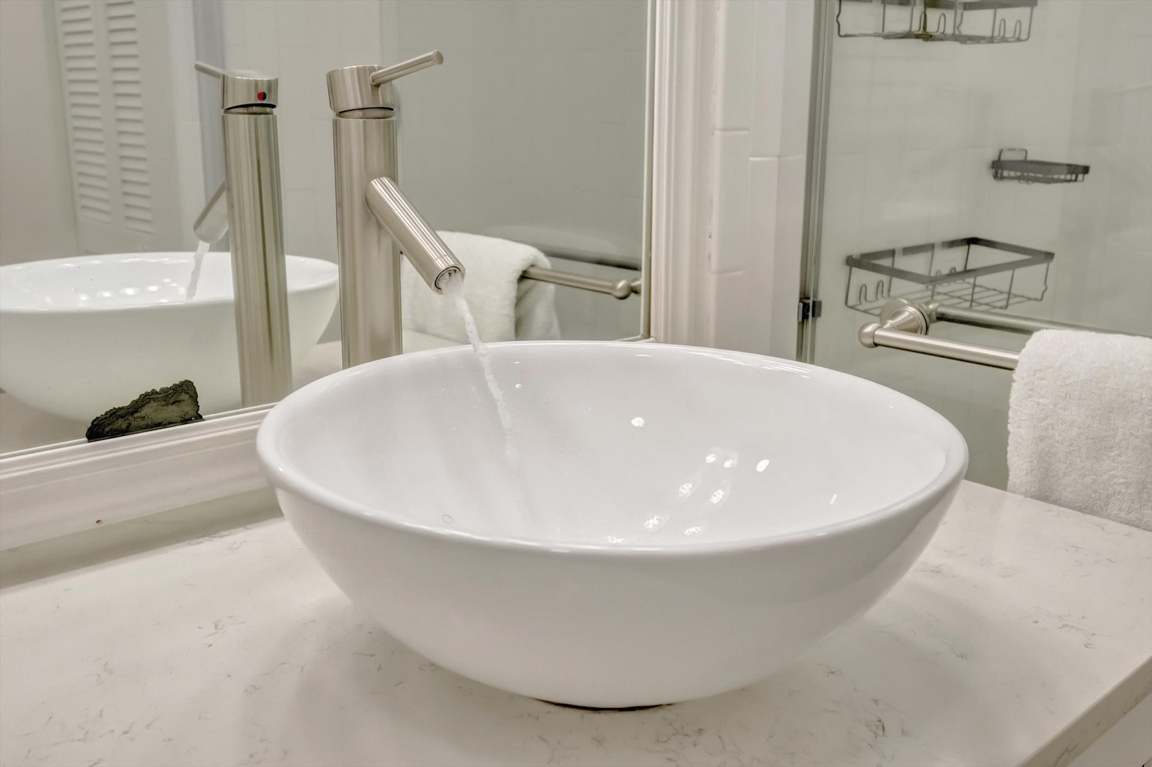Refresh in your modern bathroom, where clean lines meet thoughtful design. The sleek vessel sink and elegant brushed-nickel faucet invite you to unwind after a day exploring.